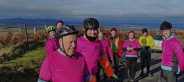A group of cyclists smiling to the camera during the break