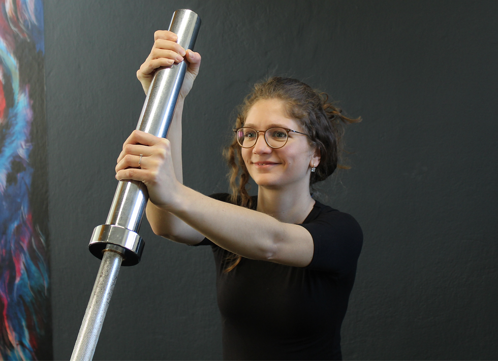 Mädchen drückt Hantel beim Krafttraining