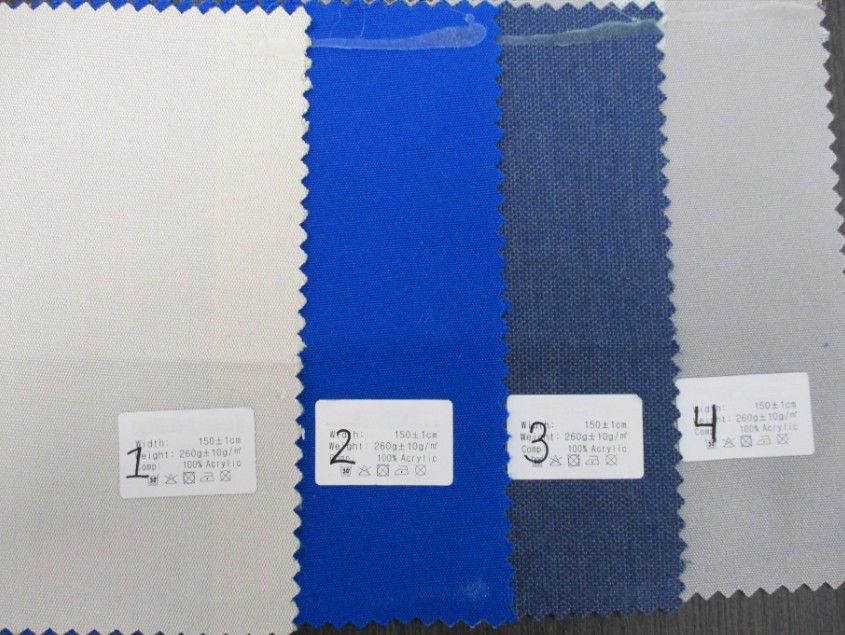 Four fabric test swatches of various colors with labels showing material content