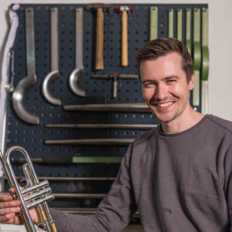 Portrait von Felix Petersik (Petersik Instruments) bei der Arbeit: Präzise Lichtsetzung mit Studioblitz an einer Trompete.