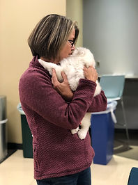 Woman holding a puppy during an event, highlighting compassionate care provided by Midwest Animal Rescue & Services