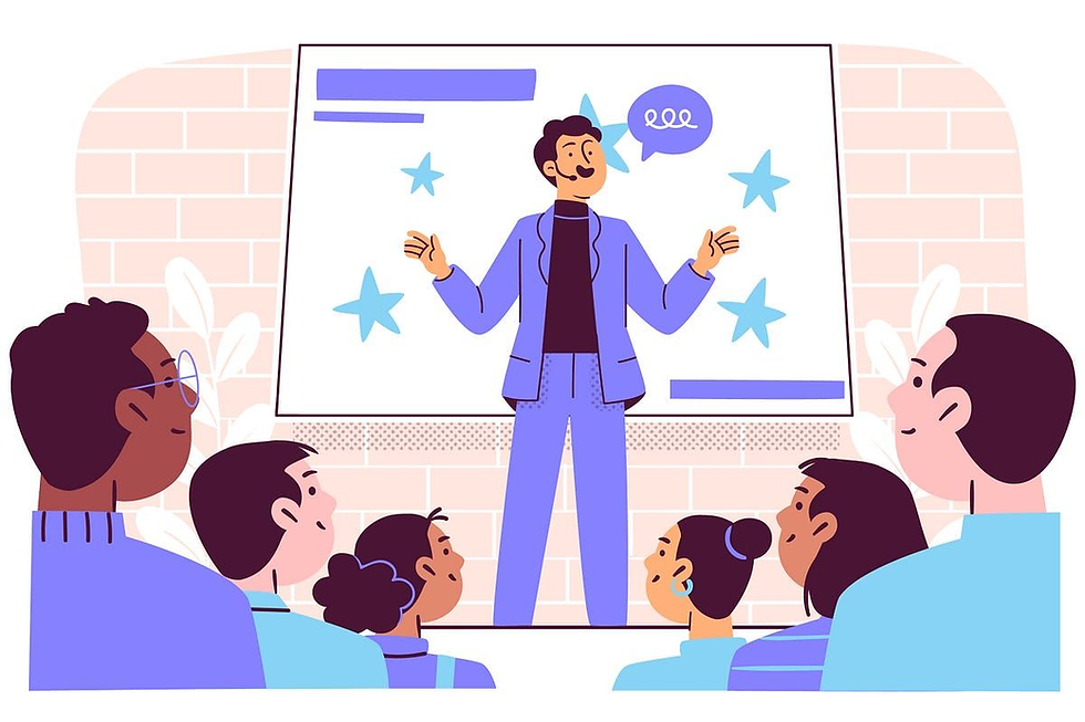 Presenter speaks to a seated audience in a classroom, gesturing before a screen with stars and a speech bubble.