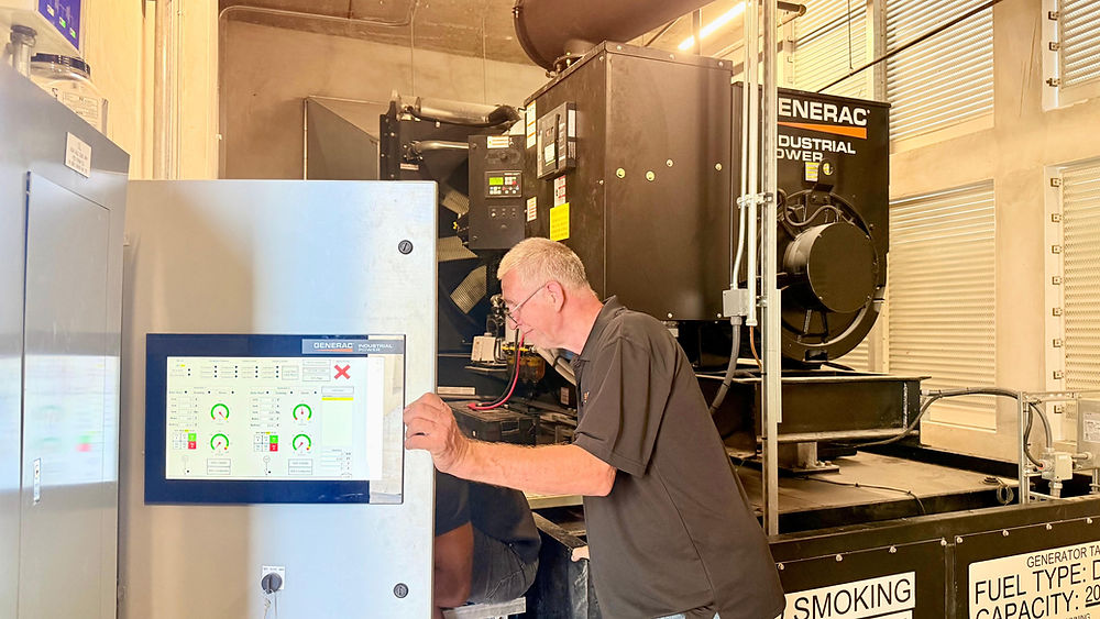 Technician performing generator maintenance, checking controls.