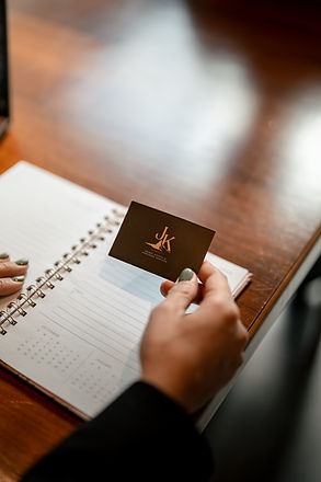 A hand holding a Zermatt Events card over an open notebook