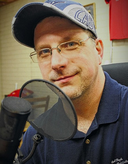 Picture of Ed Money in front of a Microphone.