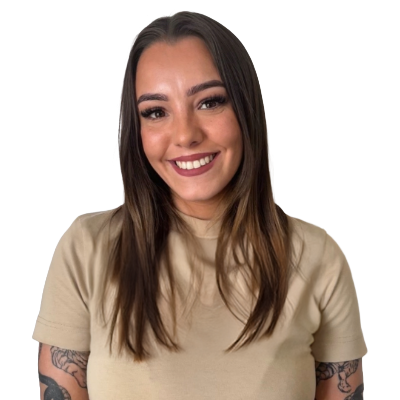 Smiling woman with brown hair and tattoos on her arms.