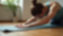 woman with her hair in a bun, stretching on a yoga mat with soft lighting