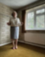 A strict Governess flexing a cane in an old-fashioned room