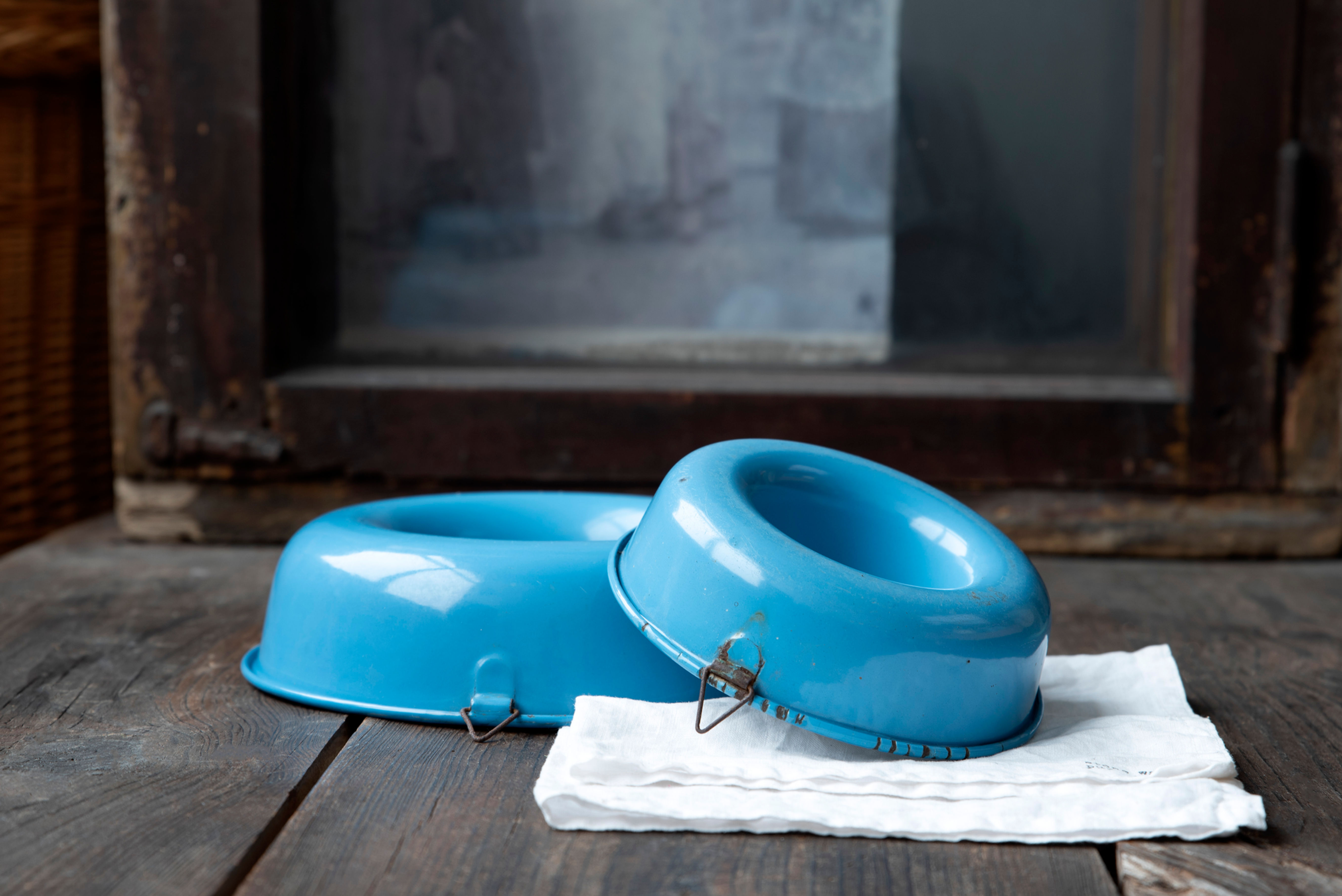 Vintage blue enamel cake tin with patina on rustic wooden table