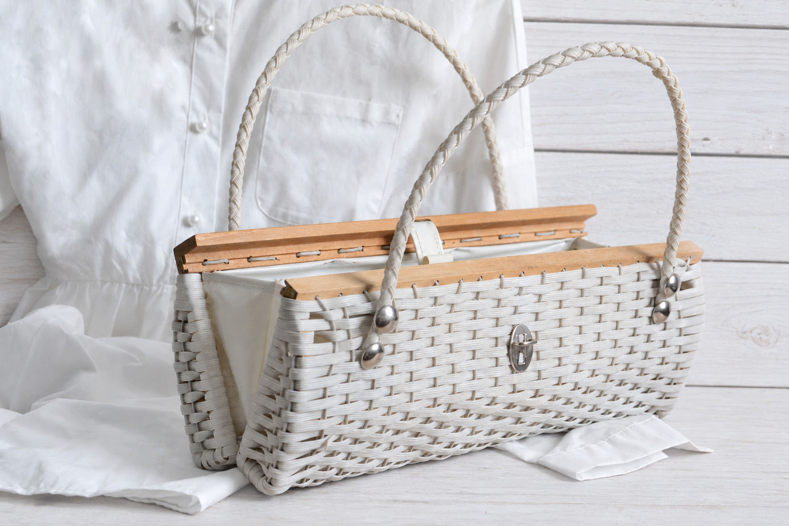 Vintage white woven mid-century handbag with braided handles, wooden frame details and silver-tone metal clasp