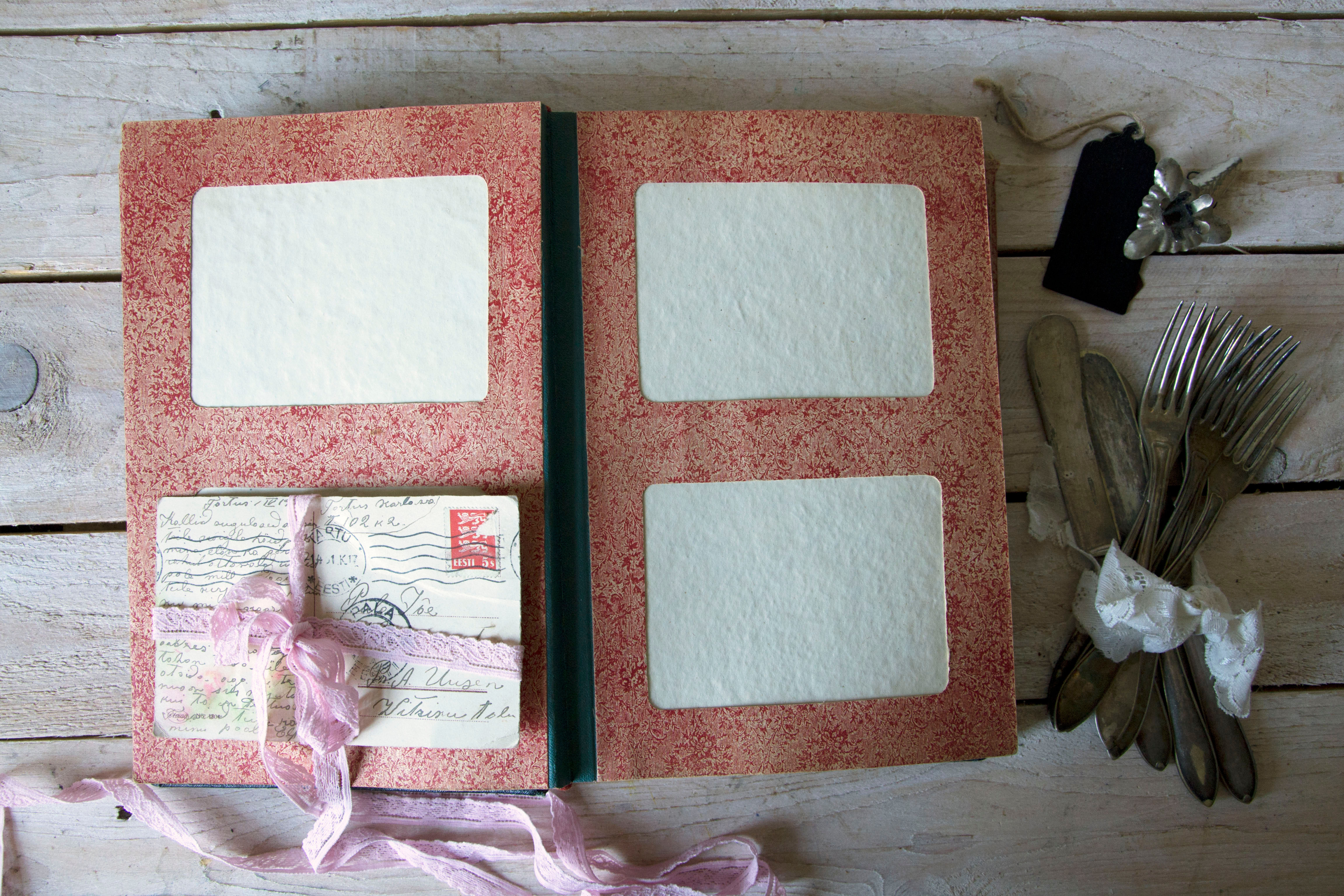 Vintage postcard album with rose-patterned pages and cardboard frames
