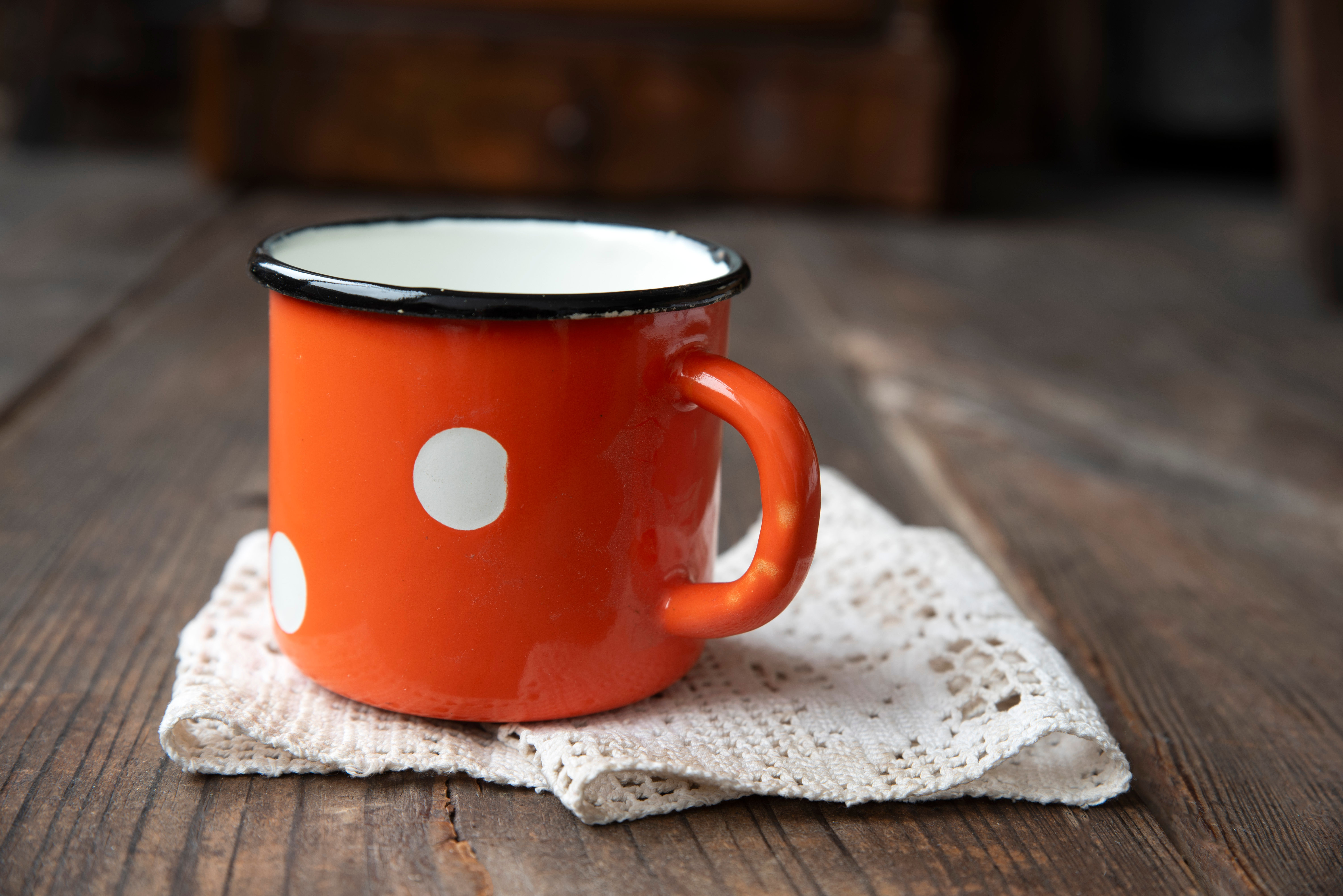 Vintage enamel mug with white polka dots and black rim