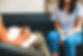 Psychologist Session | Individual Therapy Session | Individual Counseling Session with Psychologist taking notes with pen and paper and client sitting with hands clasped on couch in background