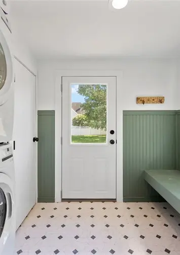 Tile laundry toom, green walls, stack appliances
