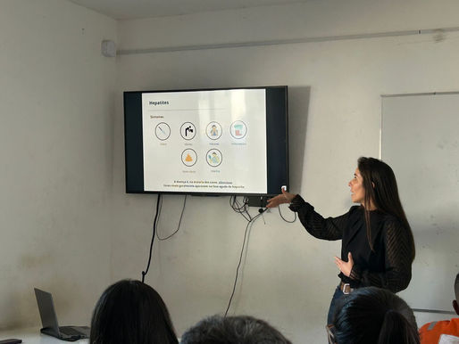 Palestrante explicando conteúdo na tela sobre as hepatites virais