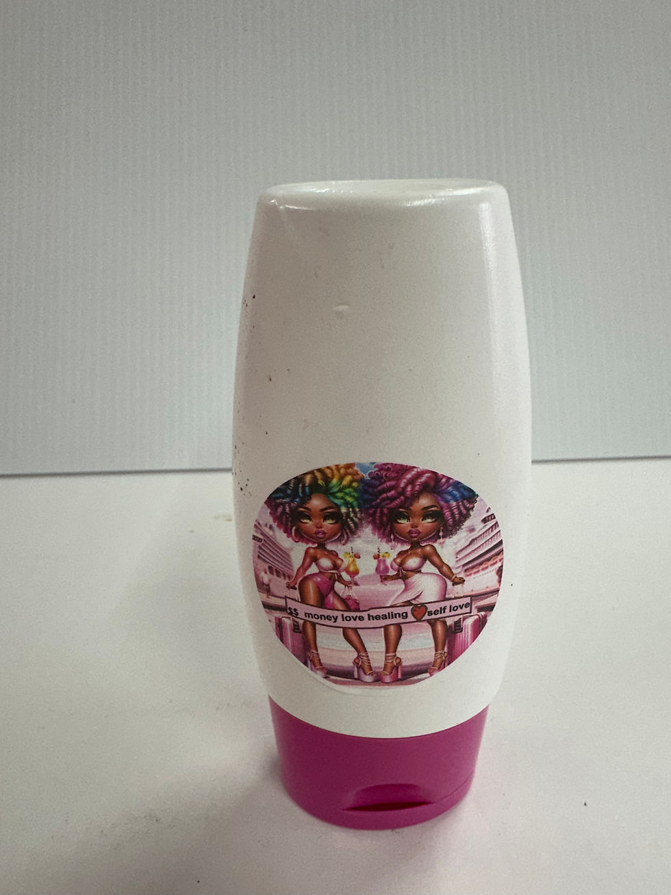 White bottle with colorful image of two dolls and Sea Moss Me Now.