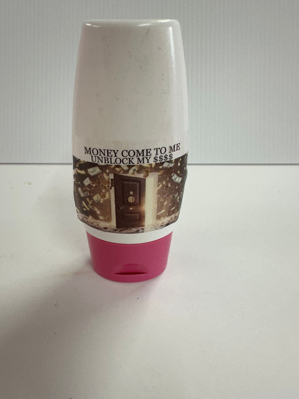 Bottle with "MONEY COME TO ME, WELCOME MY LIFE" message; white background.