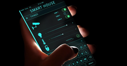 Hand holding a smartphone displaying a smart house app interface with controls for cameras, lights, and locks, in a dark setting.