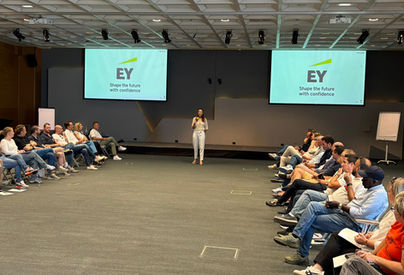 Audrey Zander leadership communication coach | An international team building and communication retreat with a multicultural leadership team, showing the team sat in a large room, following a presentation on executive communication at Ernst and Young