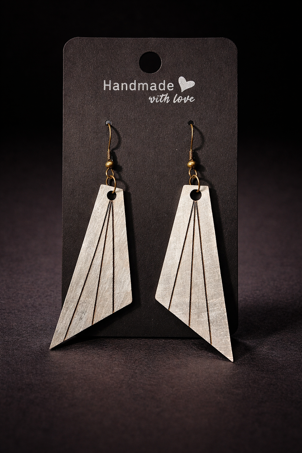 Thumbnail: Pendientes artesanales de madera pirograbada con forma geométrica tipo rombo redondeado, colgando de ganchos metálicos color