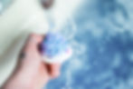 Frosting of a cupcake bath bomb being held under running water