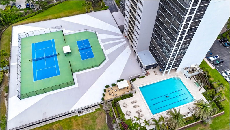 Aerial view of The Stratford at Pelican Bay swimming pool and tennis court