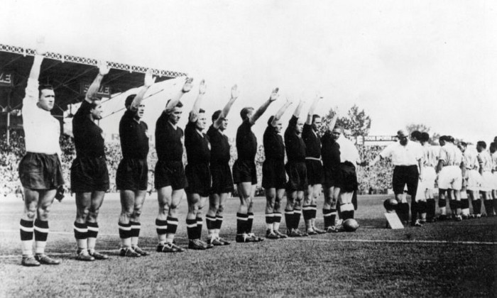 “Imagem emblemática da copa do mundo de 1938, chamada de copa do fascismo, onde os jogadores italianos fazem a saudação romana, a mando de seu ditador Benito Mussolini, a Itália jogou de preto, pela primeira vez em sua história, representando os adeptos ao movimento dos camisas negras, uma violenta ferramenta militar política fascista.” Fonte: https://calciopedia.com.br/2019/04/fascismo-futebol-italiano.html