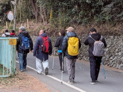 雪の舞う中、あきる野市五日市をノルディックウォークで歩く参加者の様子