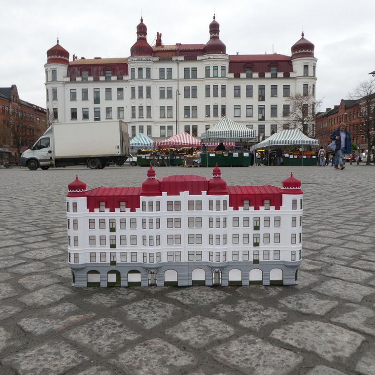 Modellen framför byggnaden på torget. Den står på kullerstenen mitt på torget.