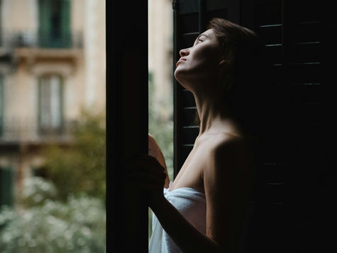 Frau blickt aus einem Fenster in weiches Tageslicht – Chiq Aesthetics, Hannover