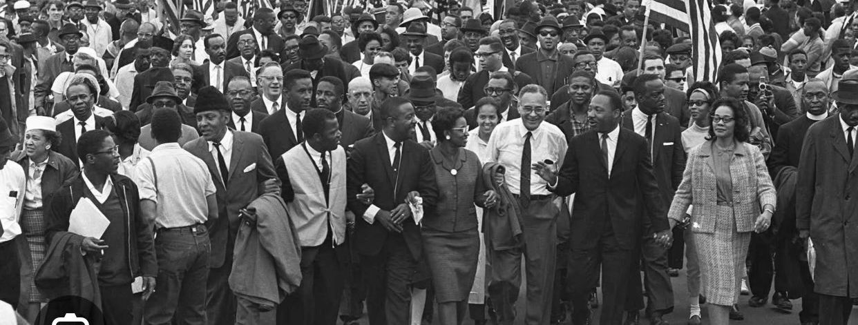 An iconic photograph from the Civil Rights march that has MLK, John Lewis and others linking hands and walking in tandem