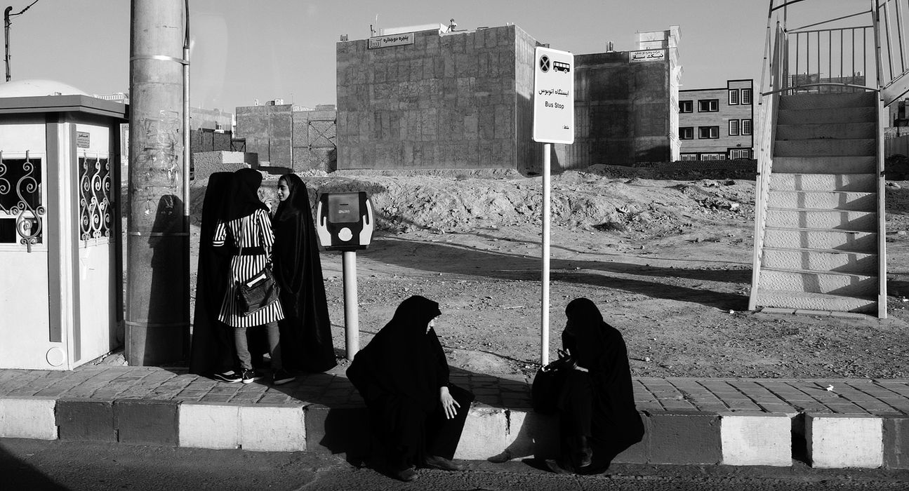 Group of women at a bus top in Iran. Black and white photo.