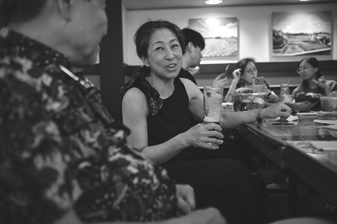 Female smiles while holding a tall glass.