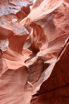 Close-up view of smooth, curved red rock textures inside Waterholes Canyon