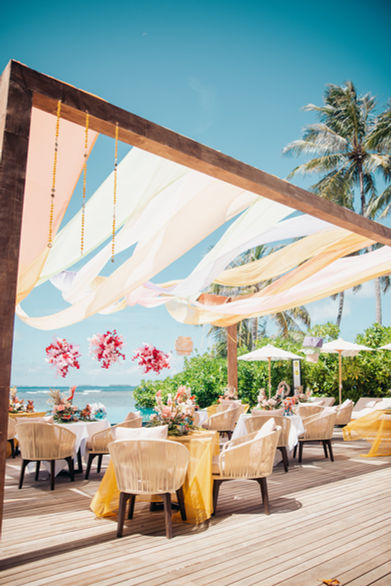 Vibrant outdoor deck decor for a large Indian destination wedding at Anantara Maldives.