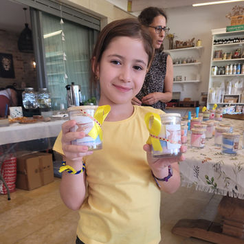 ילדה מחזיקה נרות שיצרה