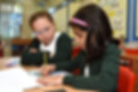 Children sat at a table working through a worksheet