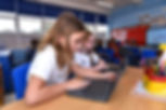 Children sat at a desk with a laptop