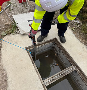 Engineer performing Openreach PIA S7 underground cabling work, accessing a telecoms chamber to install fibre optic cable within underground duct infrastructure for broadband network deployment.