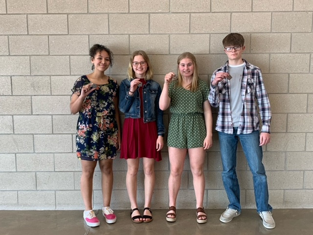 Nevaeh, Ava, Bri, and Ian holding medals