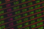 a digital board shows green and red numbers representing stocks and changes on a black background