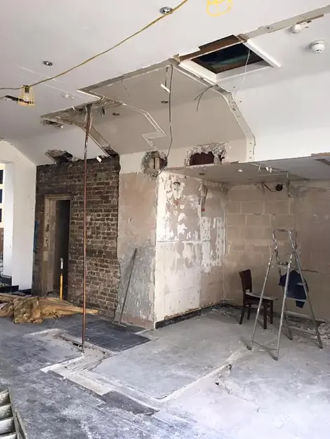 an empty room with a ladder and chairs in it