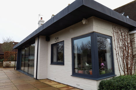a white brick house with black windows and a black roof