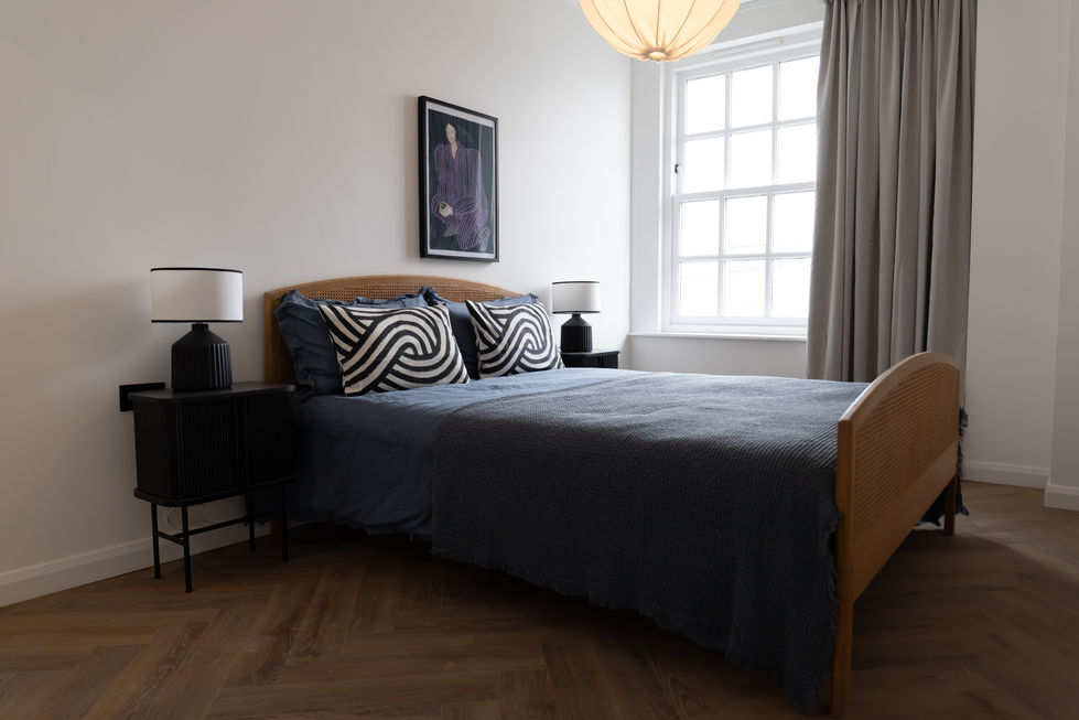 a bedroom with a bed and a picture on the wall above it