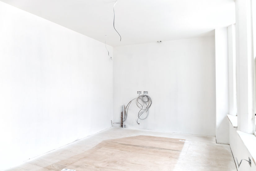 an empty room with electrical wires hanging from the ceiling