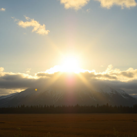 beautiful bright yellow sun coming out of the clouds in southeast alaska.jpg
