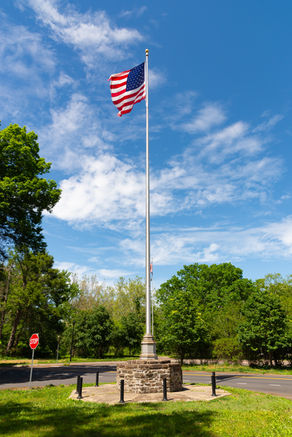 Waving American Flag with blue skies and clouds at Washington Crossing Historic Park in Washington Crossing, Pennsylvania, USA.