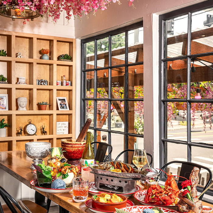 Restaurant dining room with a cherry blossom ceiling and a table full of dishes