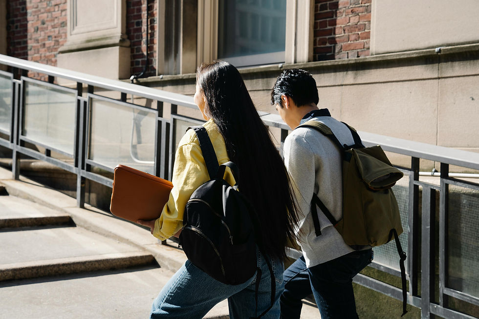 Two students walking up steps with backpacks and a laptop, representing education and future opportunities.