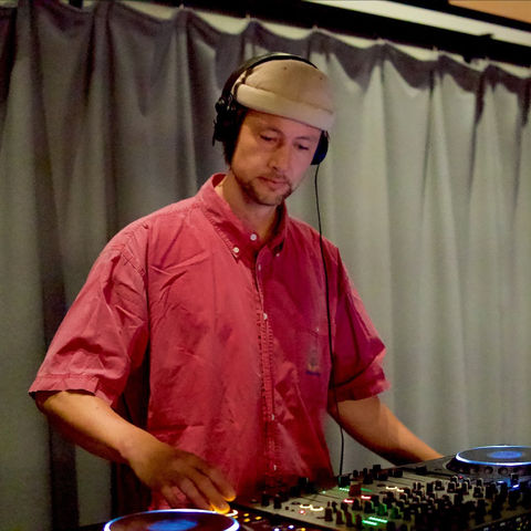 Schei at the decks with headphones on
